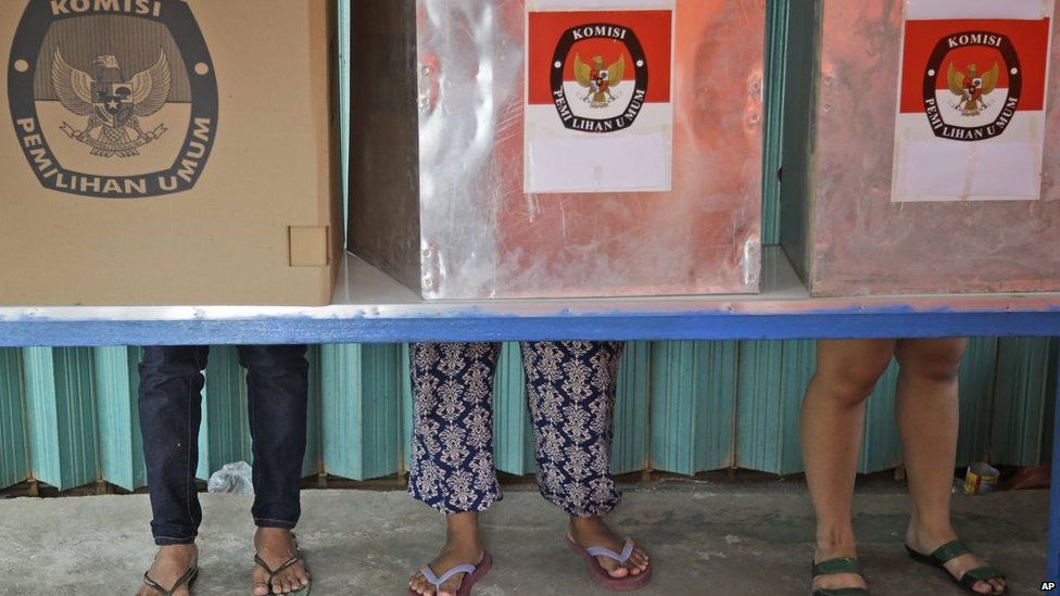 Indonesians vote in booths during the parliamentary election at a polling station in Jakarta, Indonesia on Wednesday, 9 April, 2014