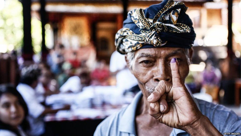 A man shows his ink-stained finger after casting his ballot during legislative elections on 9 April, 2014 in Denpasar, Bali, Indonesia