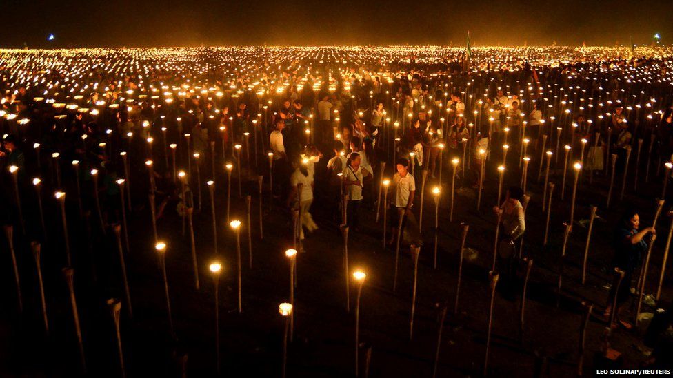 Volunteers light candles
