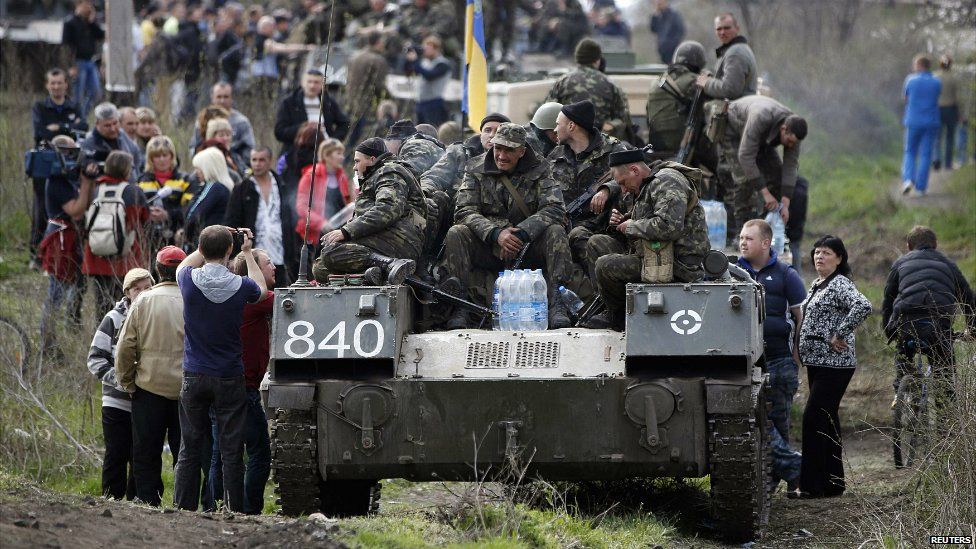 Ukrainian soldiers sit on top of armoured personnel carriers while surrounded by pro-Russian protesters in Kramatorsk, in eastern Ukraine April 16, 2014