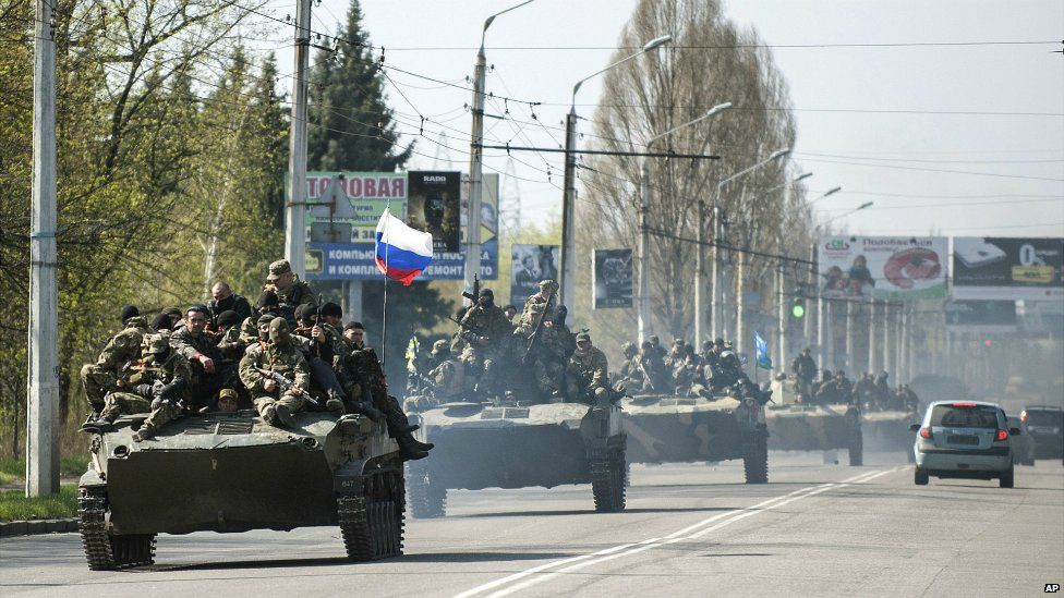 A column of combat vehicles with a Russian flag on the front one makes its way to the town of Kramatorsk on Wednesday, April 16, 2014