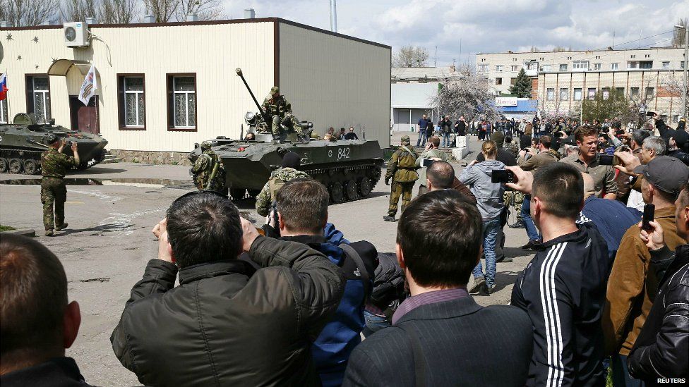 People take pictures of pro-Russian gunmen on armoured vehicles in Sloviansk - 16 April 2014