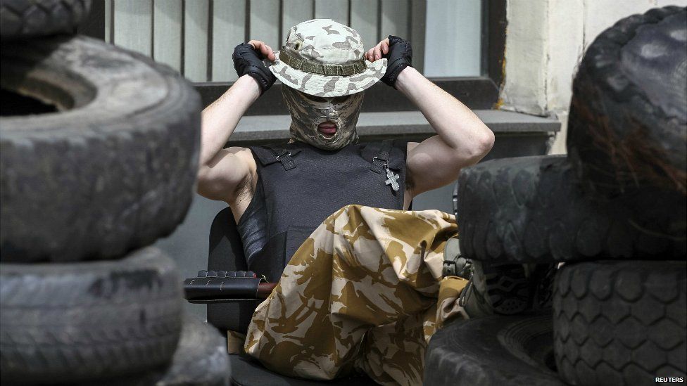 A pro-Russian armed man stands guard outside the mayor's office in Donetsk - 16 April 2014