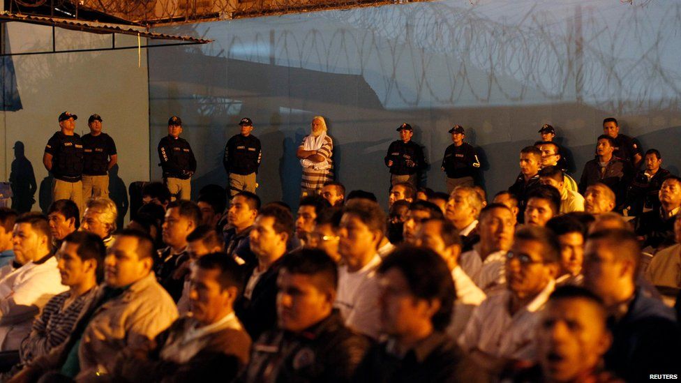 Prison guards and inmates watch other prisoners performing at the Sarita Colonia prison yard in Lima, on April 15, 2014.