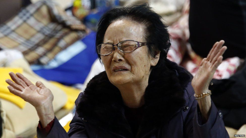 A family member cries as she waits for news from a rescue team at a gym in Jindo.