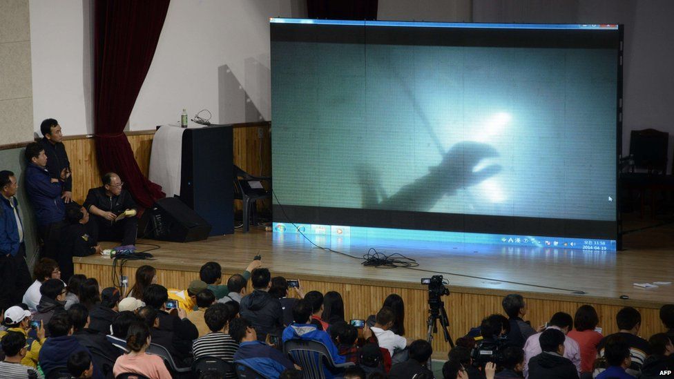 Relatives watch underwater footage of divers searching near the sunken ferry - 19 April