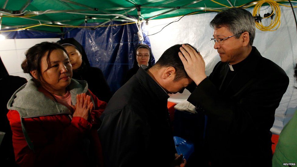 Catholic priest holds a special Easter service for the families of those missing onboard the sunken South Korean ferry Sewol, on 20 April 2014