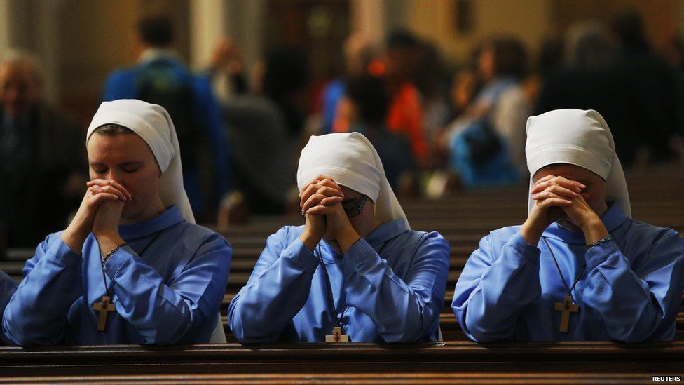Three nuns pray after the conclusion of Easter Mass at the Cathedral of the Holy Cross in Boston, Massachusetts, 20 April 2014