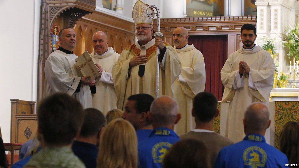 Boston Cardinal Sean O'Malley (top) blesses the 2014 Boston Marathon runners and workers at the front of the Cathedral of the Holy Cross during Easter Mass in Boston, Massachusetts, 20 April 2014