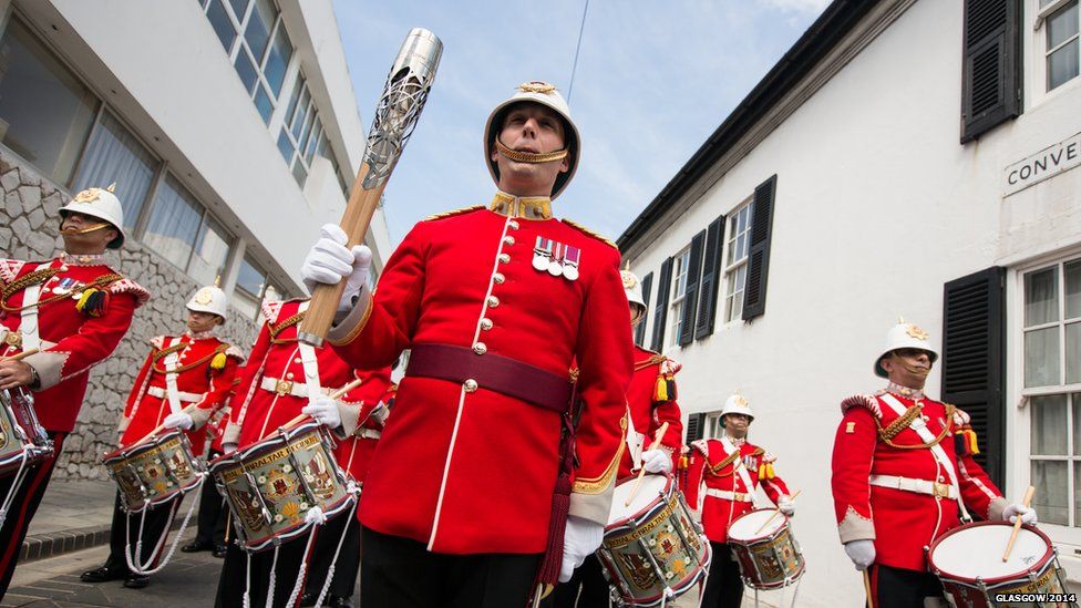 A military band perform with the Queen's Baton.