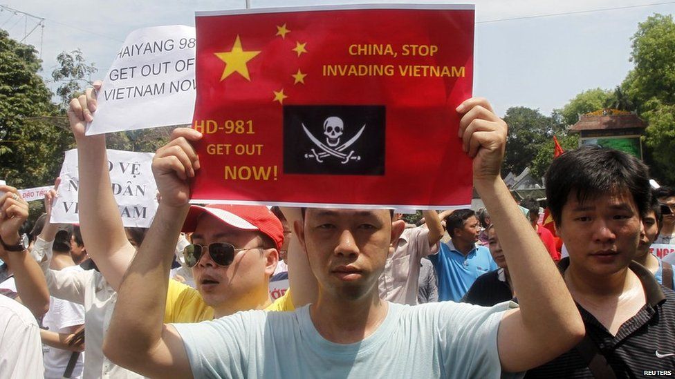 Protesters hold anti-China placards while marching in an anti-China protest on a street in Hanoi on 11 May, 2014