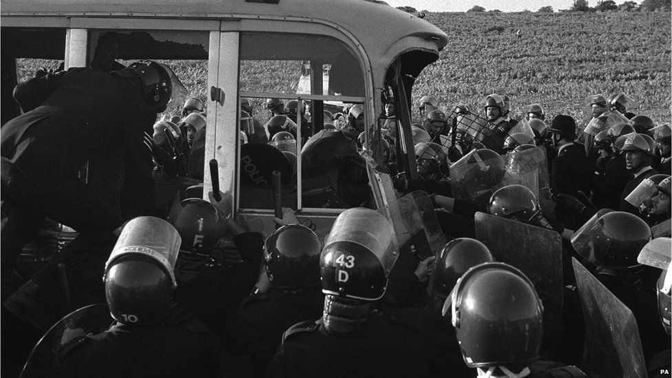 Police surround the last coach to be stopped from racing round the field near Stonehenge where violence erupted in 1985