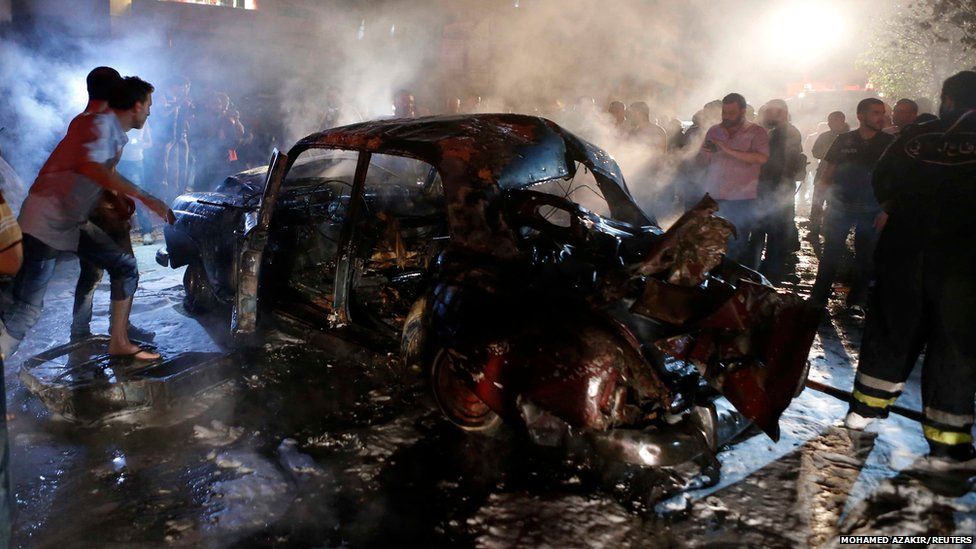 People gather at the site of an explosion at the southern suburbs of the Lebanese capital Beirut