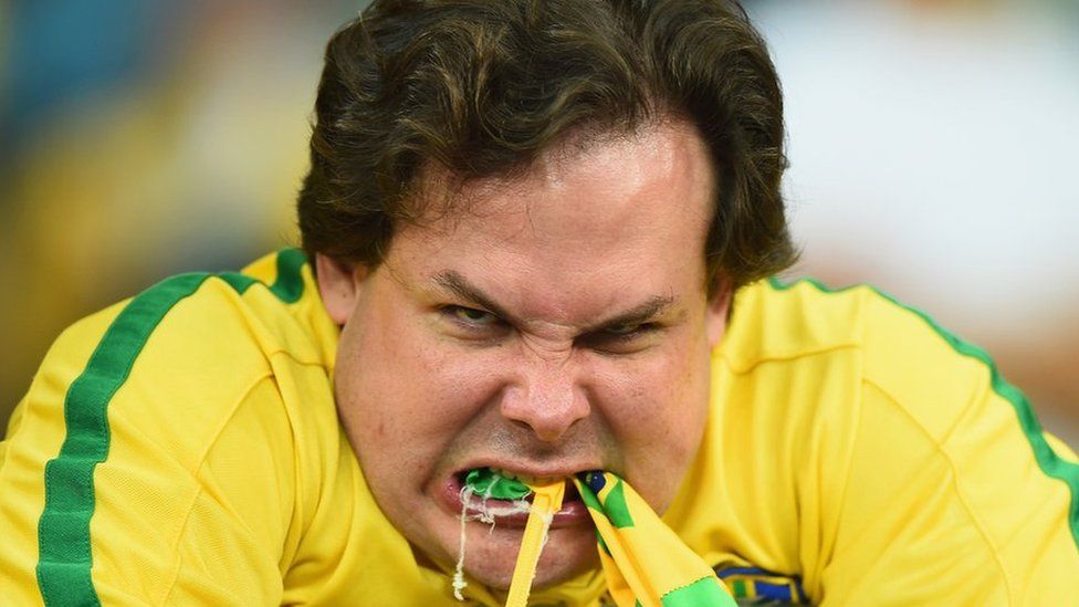 An emotional Brazil fan reacts after being defeated by Germany 7-1 on 8 July 2014