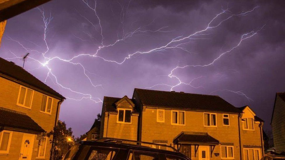 Lightning seen over houses at night