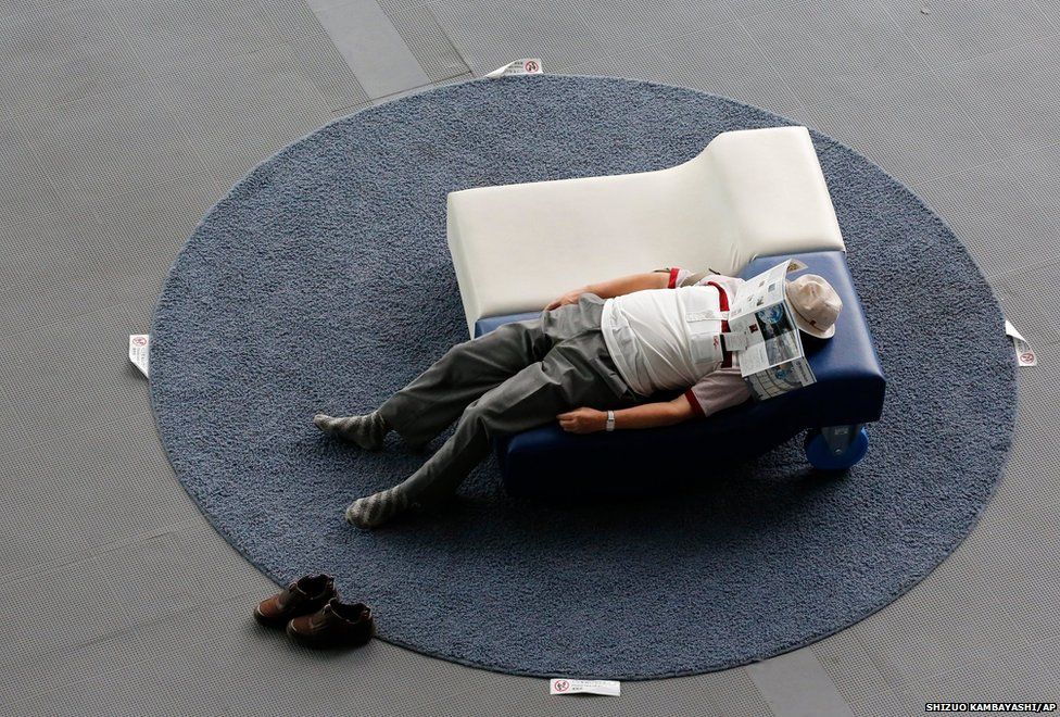 A visitor takes a nap on a couch at the National Museum of Emerging Science and Innovation, in Tokyo