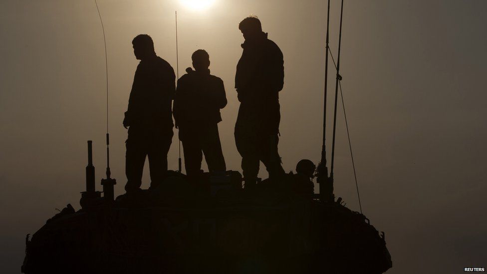 Israeli soldiers stand atop a tank near the border with Gaza 29 July 29 2014