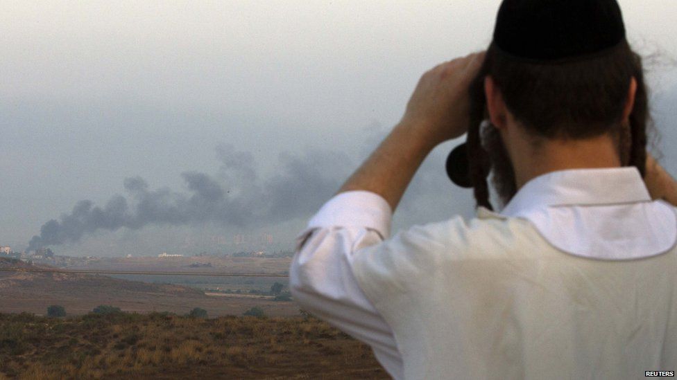 An Israeli man looks through binoculars towards the Gaza Strip near the southern town of Sderot July 29, 2014.