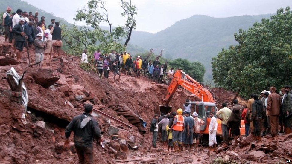 Rescuers work at the site of a landslide in Malin village, in the western Indian state of Maharashtra, Wednesday, July 30, 2014.
