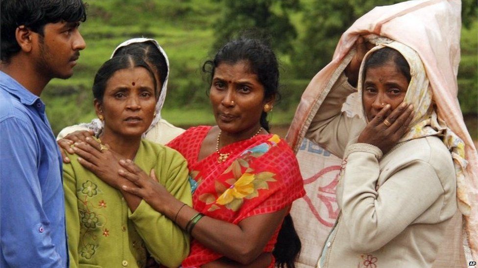 Villagers console each other as they watch a rescue operation at the site of a landslide in Malin village, in the western Indian state of Maharashtra, Wednesday, July 30, 2014.