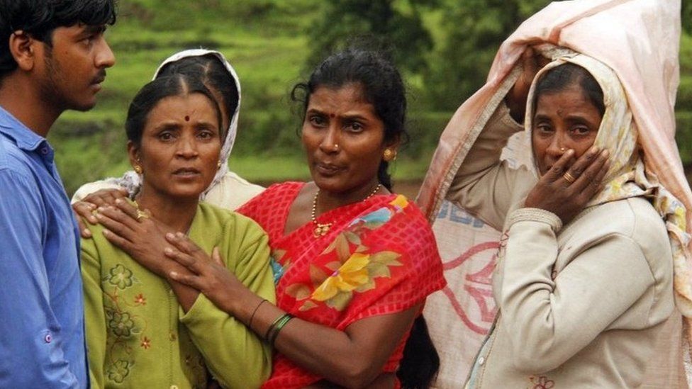 Villagers console each other as they watch a rescue operation at the site of a landslide in Malin village, in the western Indian state of Maharashtra, Wednesday, July 30, 2014.
