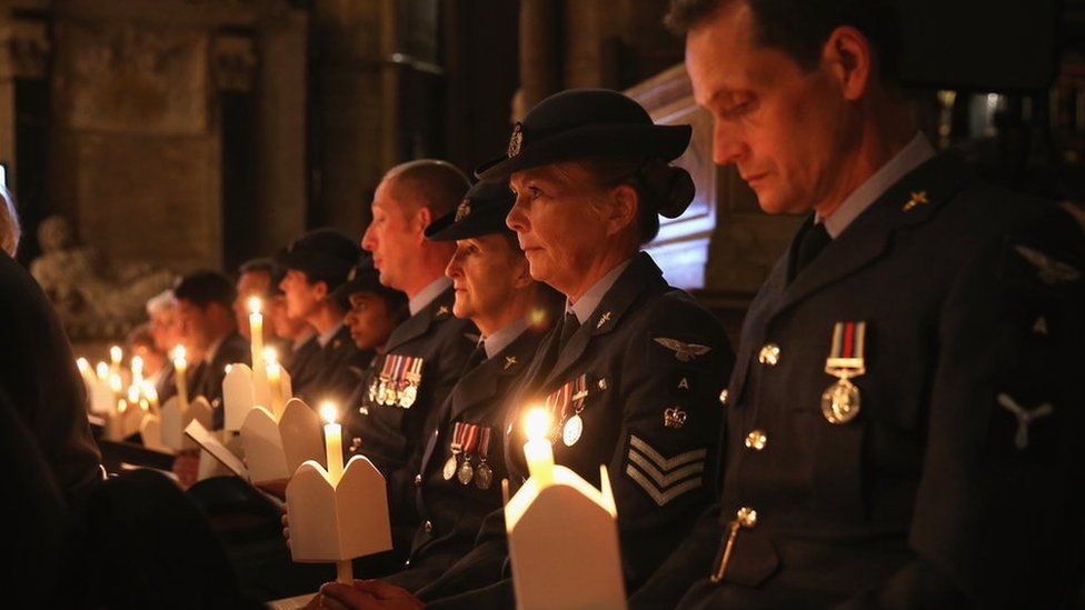 The congregation at a service in Westminster Abbey hold candles