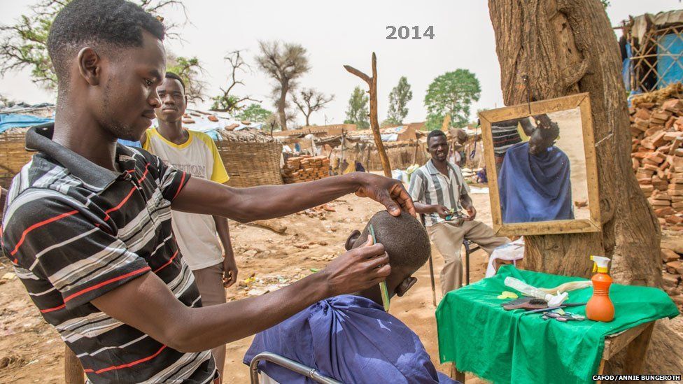 A man cutting hair at Khamsa Dagiag camp in Darfur, Sudan - 2014