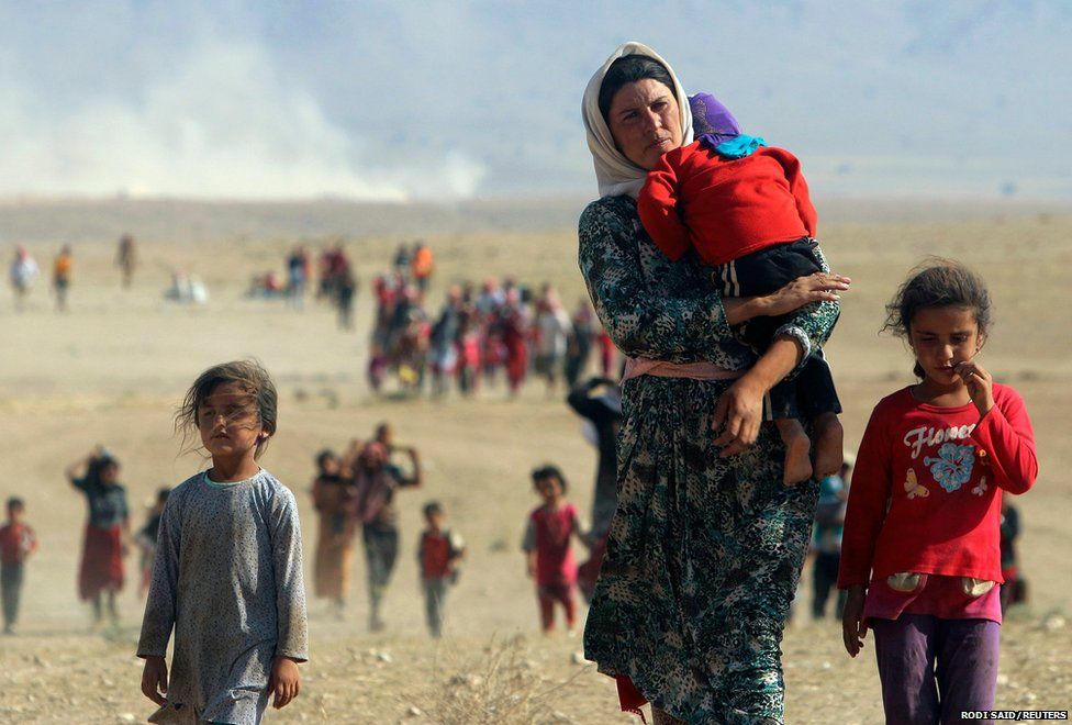 Displaced Yazidis flee violence in Sinjar town and walk towards the Syrian border