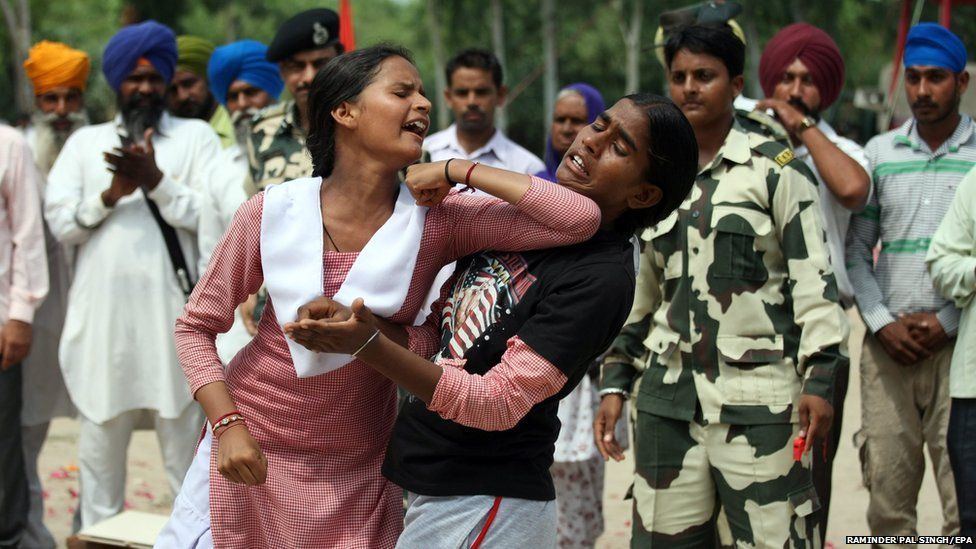 People watch as Indian school girls demonstrate self-defence techniques learnt from Border Security Force (BSF) personnel in Ballaharwal