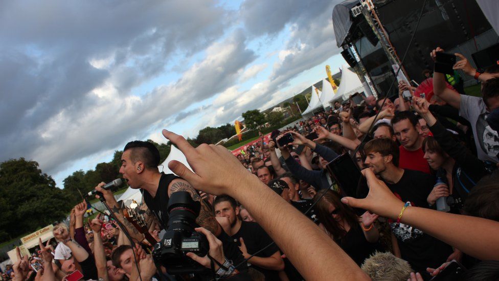 Canwr y band Anti-Flag yn perfformio ymysg y gynulleidfa // The Anti-Flag singer performing amongst the crowd