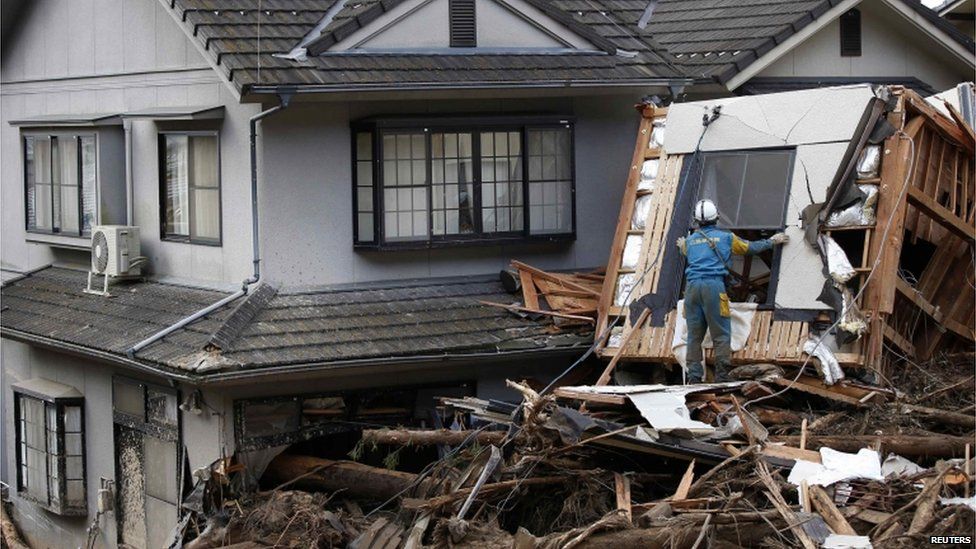 A police officer searches for survivors at a site where a landslide swept through a residential area at Asaminami ward in Hiroshima, western Japan, on 21 August, 2014