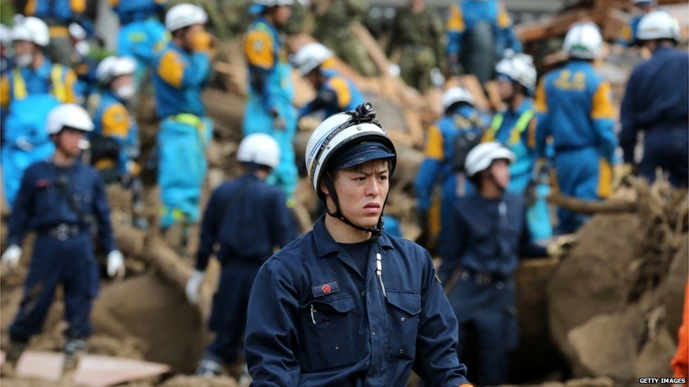 Members of Japan's Ground Self-Defense Force continue the search for missing people among the debris of house destroyed by a landslide caused by torrential rain at the site of a landslide in a residential area on 21 August, 2014 in Hiroshima, Japan
