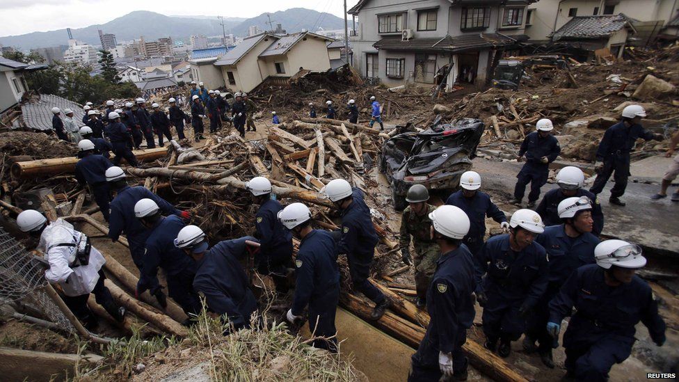 Police officers move to higher ground after an announcement to evacuate due to another landslide, as they search for survivors at the site where Wednesday's landslide swept through a residential area at Asaminami ward in Hiroshima, western Japan, on 22 August, 2014