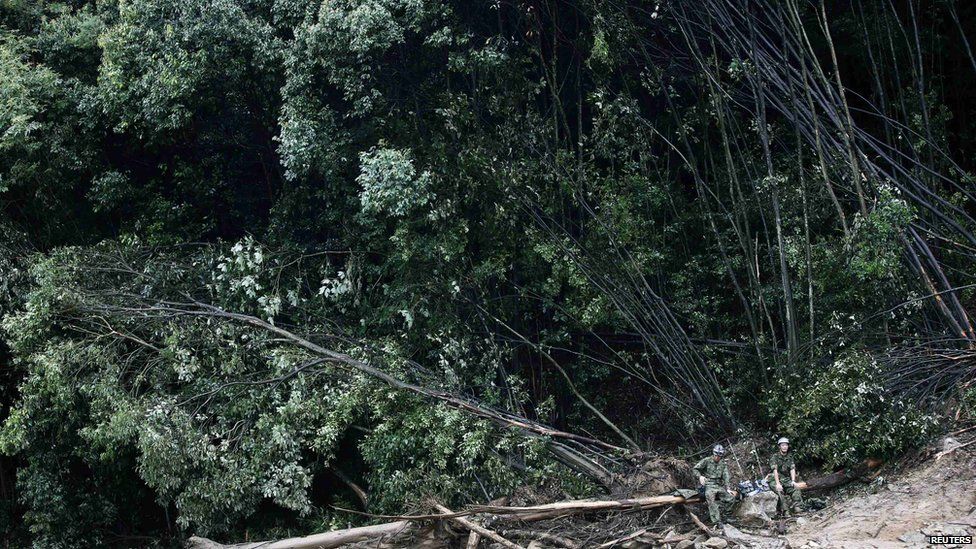 Japan Self-Defense Force soldiers sit as they search for survivors at a site where a landslide swept through a residential area at Asaminami ward in Hiroshima, western Japan, on 22 August, 2014
