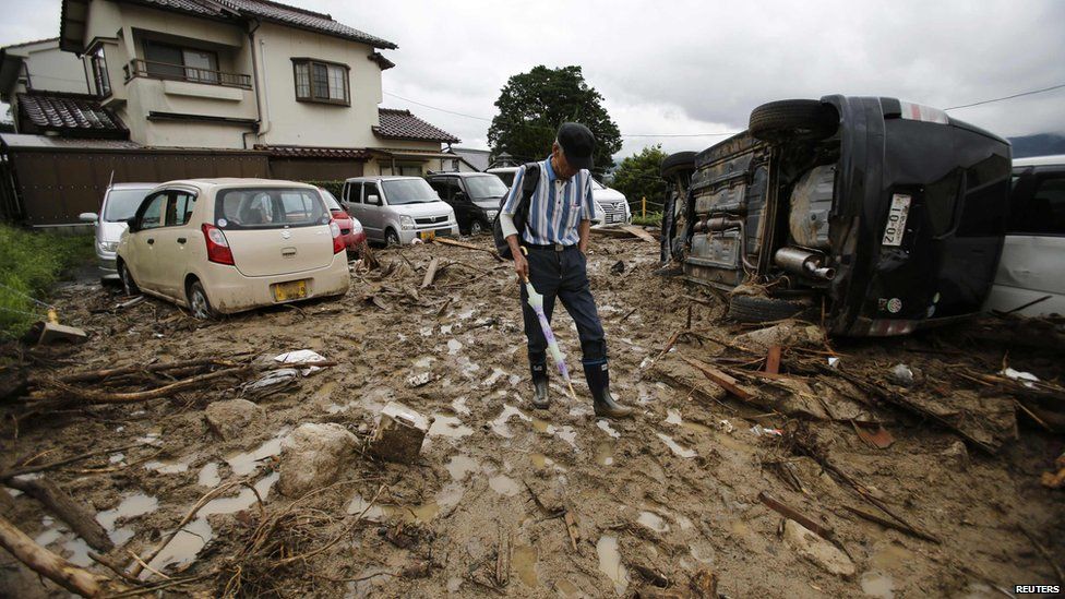 A man walks at a site where a landslide swept through a residential area at Asaminami ward in Hiroshima, western Japan, on 22 August, 2014