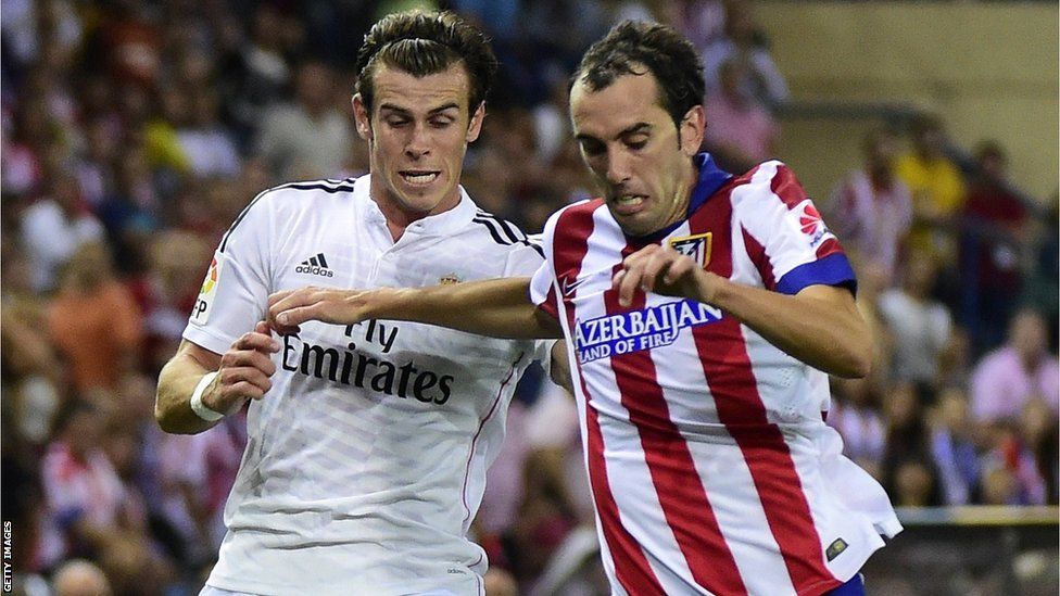 Real Madrid's Gareth Bale vies with Atletico Madrid's Uruguayan defender Diego Godin during the Spanish Super Cup final second-leg. Atletico won the tie 2-1
