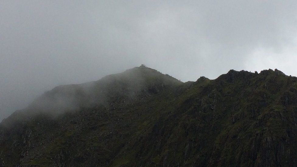Y cwmwl yn dechrau clirio o'r copa, ac mae torf yna'n barod! // The cloud's beginning to clear from the peak. Looks a bit crowded!