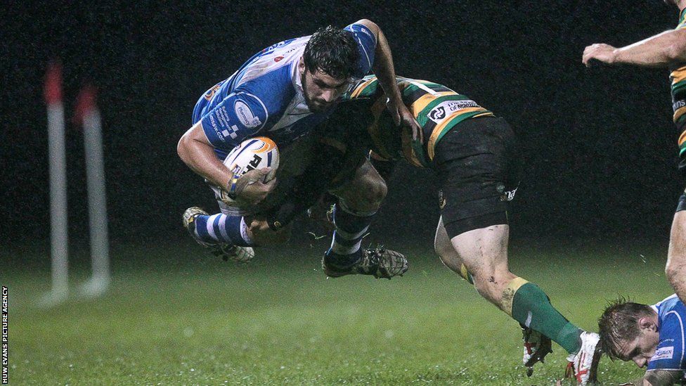 Cory Hill is tackled by Northampton's Howard Packman during Dragons' 27-25 friendly win at Ebbw Vale.
