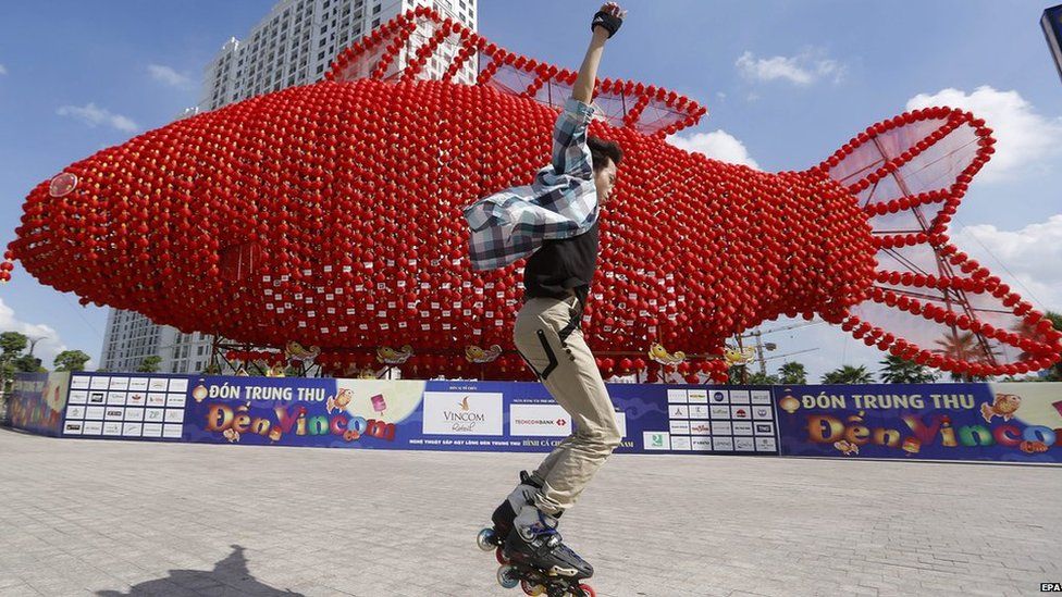 A boy rollerblades in front a carp lantern which has officially been recognized as the largest lantern in the country by the Vietnam Guinness Record in Hanoi, Vietnam on 4 September 2014