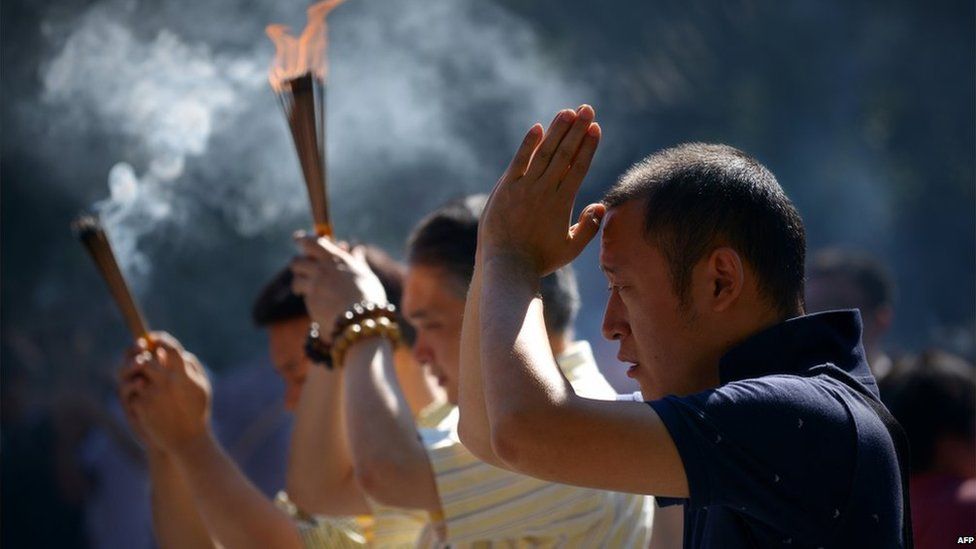People pray during the Mid-Autumn festival at Lama Temple in Beijing on 8 September, 2014