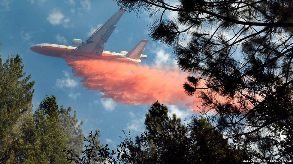 An air tanker drops a load of fire retardant on a wildfire