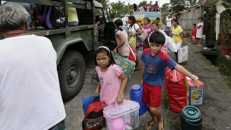 Filipino villagers carry their belongings towards military trucks during a mandatory evacuation near the restive Mayon Volcano in Guinobatan town, Albay province, Philippines on 17 September 2014