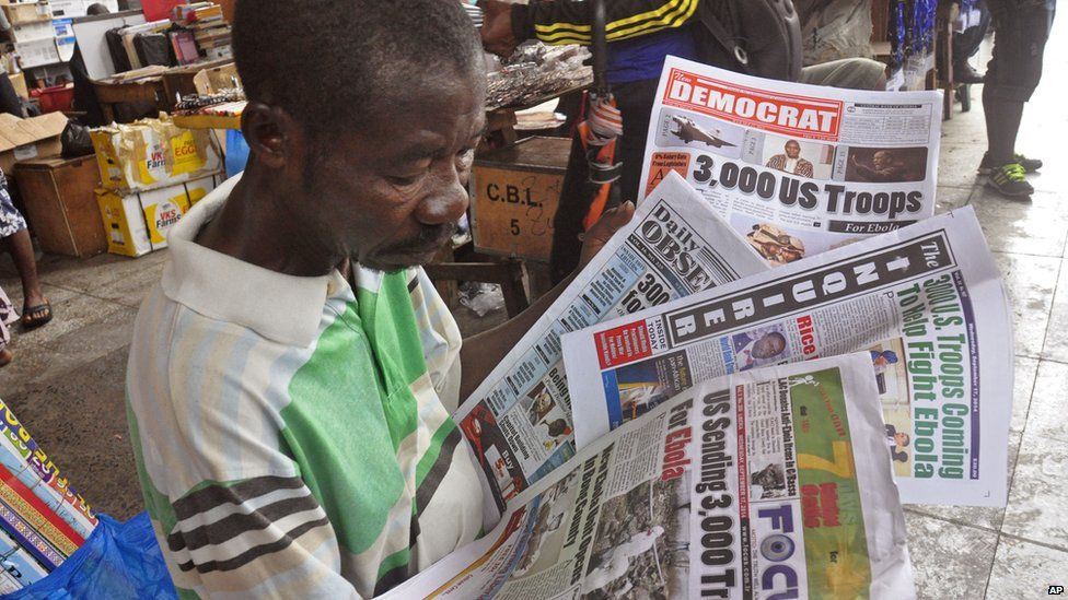 A newspaper vendor holding papers in Monrovia, Liberia - Wednesday 17 September 2014