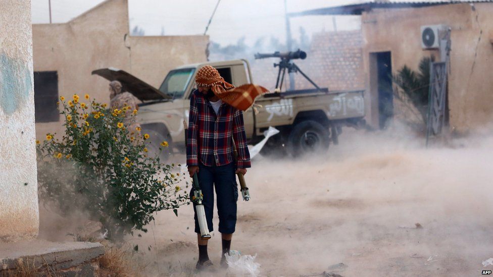 A militia fighter reacts as a gun is fired in Tripoli, Libya - Tuesday 16 September 2014