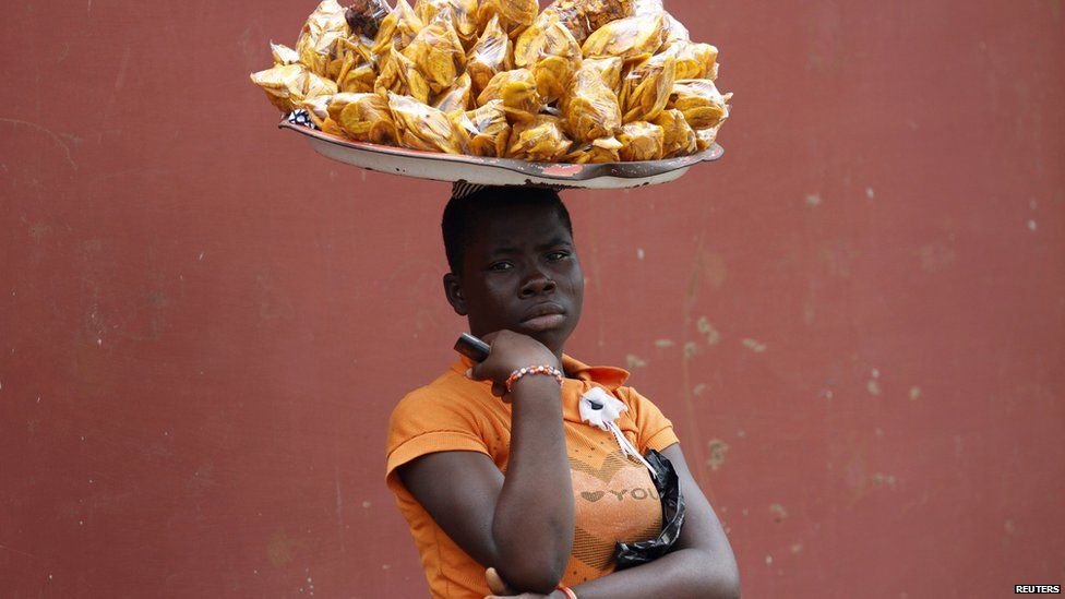 A woman with a plate of plantain chips balanced on her head - Wednesday 17 September 2014