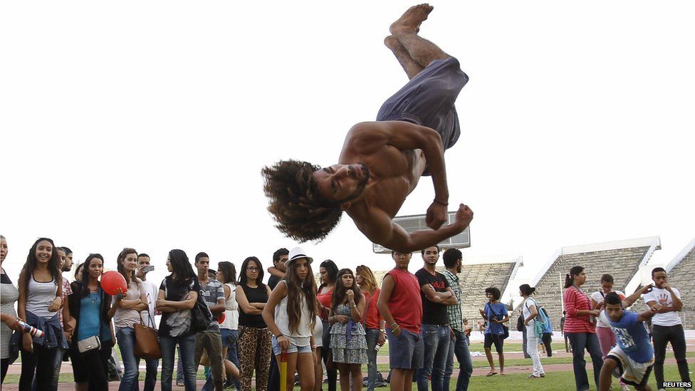 People watch as a man practices flips in Tunis on 21 September 2014