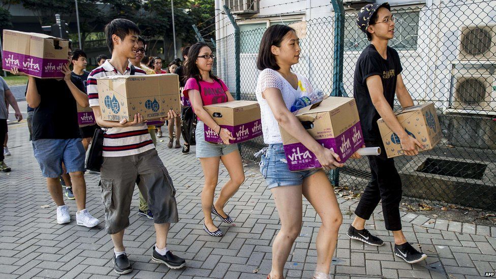Volunteers carry food and water during a demonstration outside the government headquarters in Hong Kong on 28 September, 2014