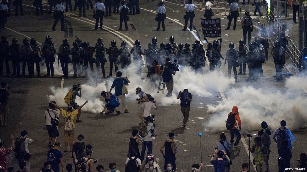 Demonstrators disperse as tear gas is fired by police during a protest on 29 September 2014 in Hong Kong.