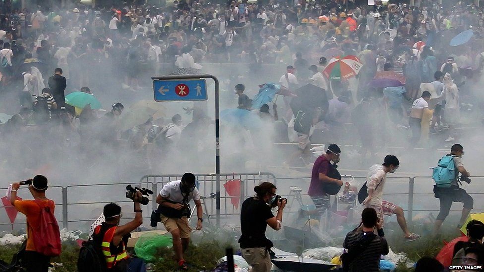People disperse after police fired tear gas upon pro-democracy demonstrators near the Hong Kong government headquarters on 28 September 2014.