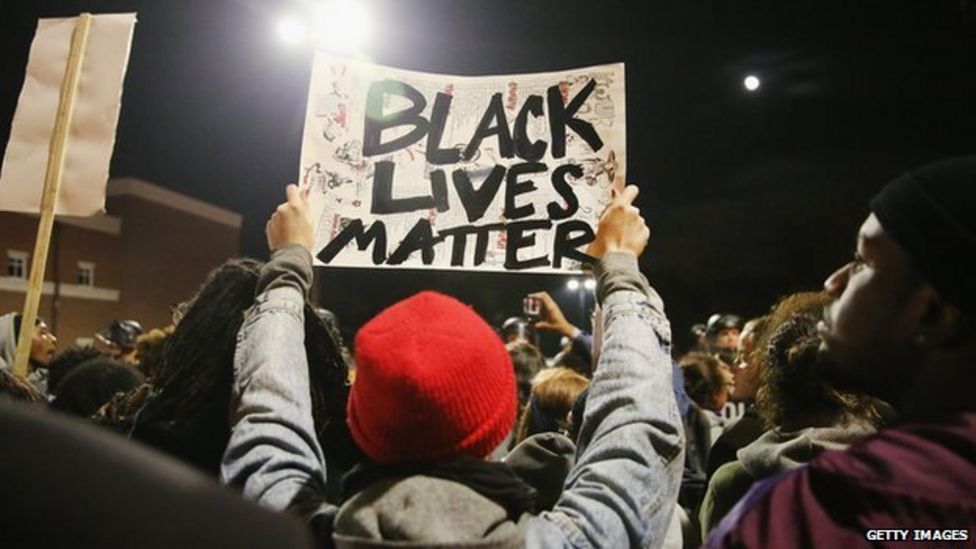 A man holds up a sign reading "black lives matter" at a protest in Ferguson, Missouri.